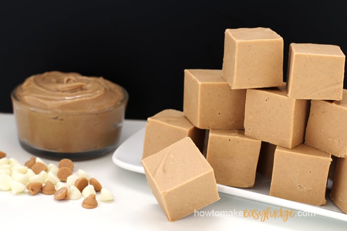 bowl of peanut butter, white chocolate chips and peanut butter chips sitting on table next to a plate of homemade peanut butter fudge