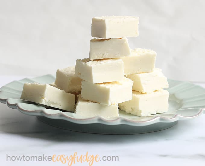 stack of easy 2-ingredient white chocolate fudge on plate, cut in squares