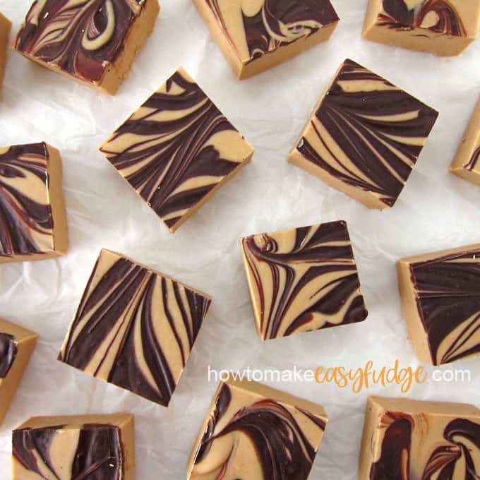 squares of tiger butter fudge arranged on a wrinkled piece of parchment paper
