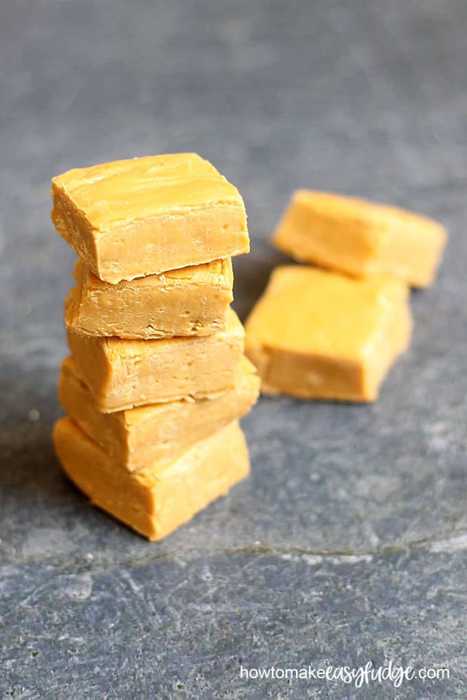Homemade butterbeer fudge stacked with black background. 