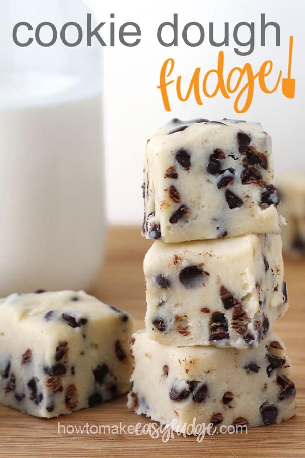 Squares of cookie dough fudge stacked up in front of a bottle filled with milk.