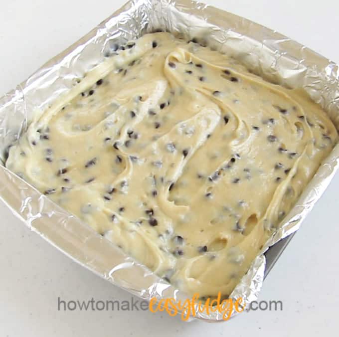 chocolate chip cookie dough in a tin foil lined 8-inch square pan