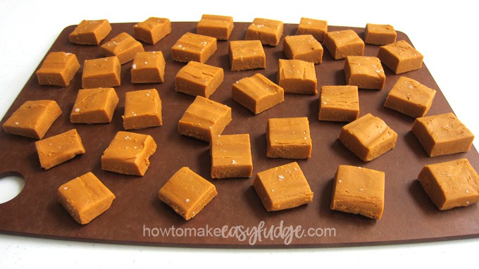 pieces of sea salt caramel fudge on a wooden cutting board