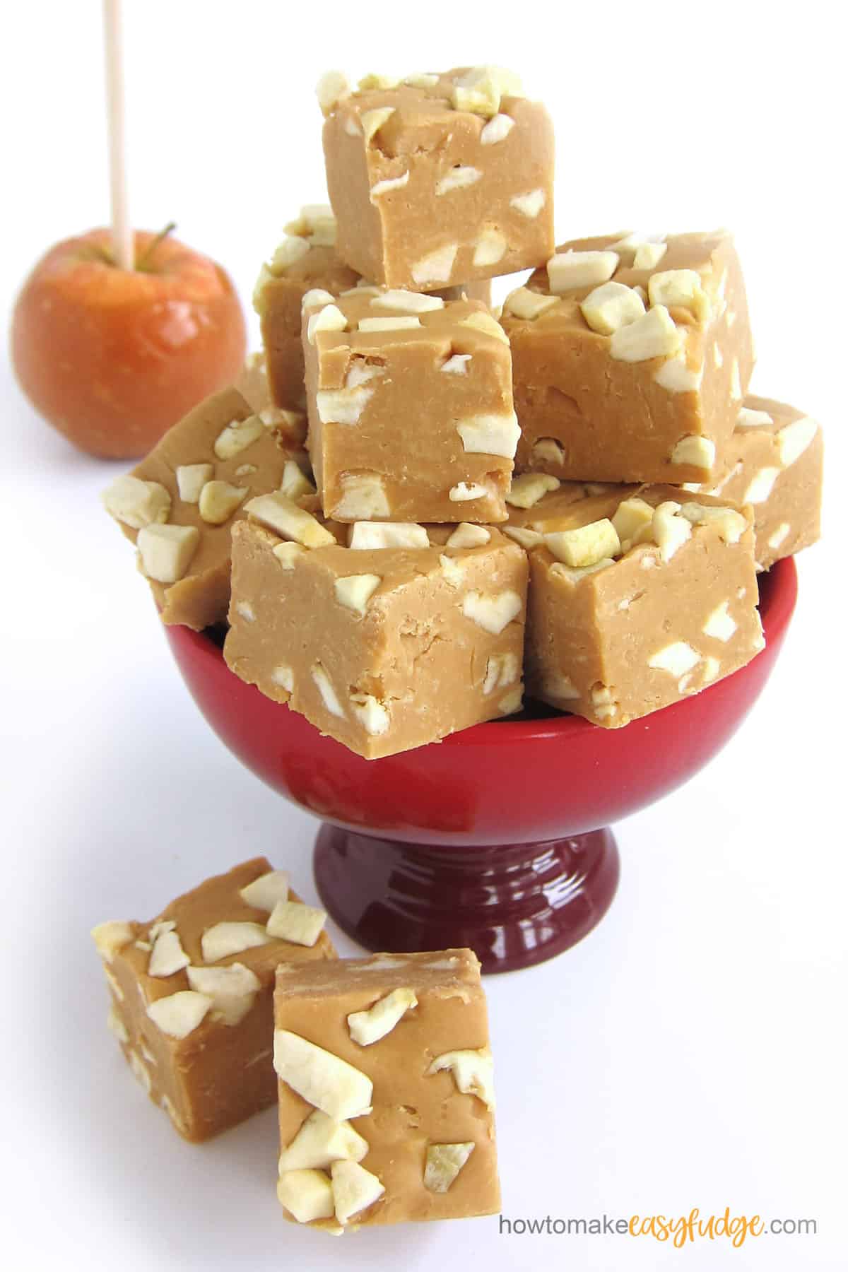 Caramel Apple Fudge displayed in a red bowl next to a caramel apple. 