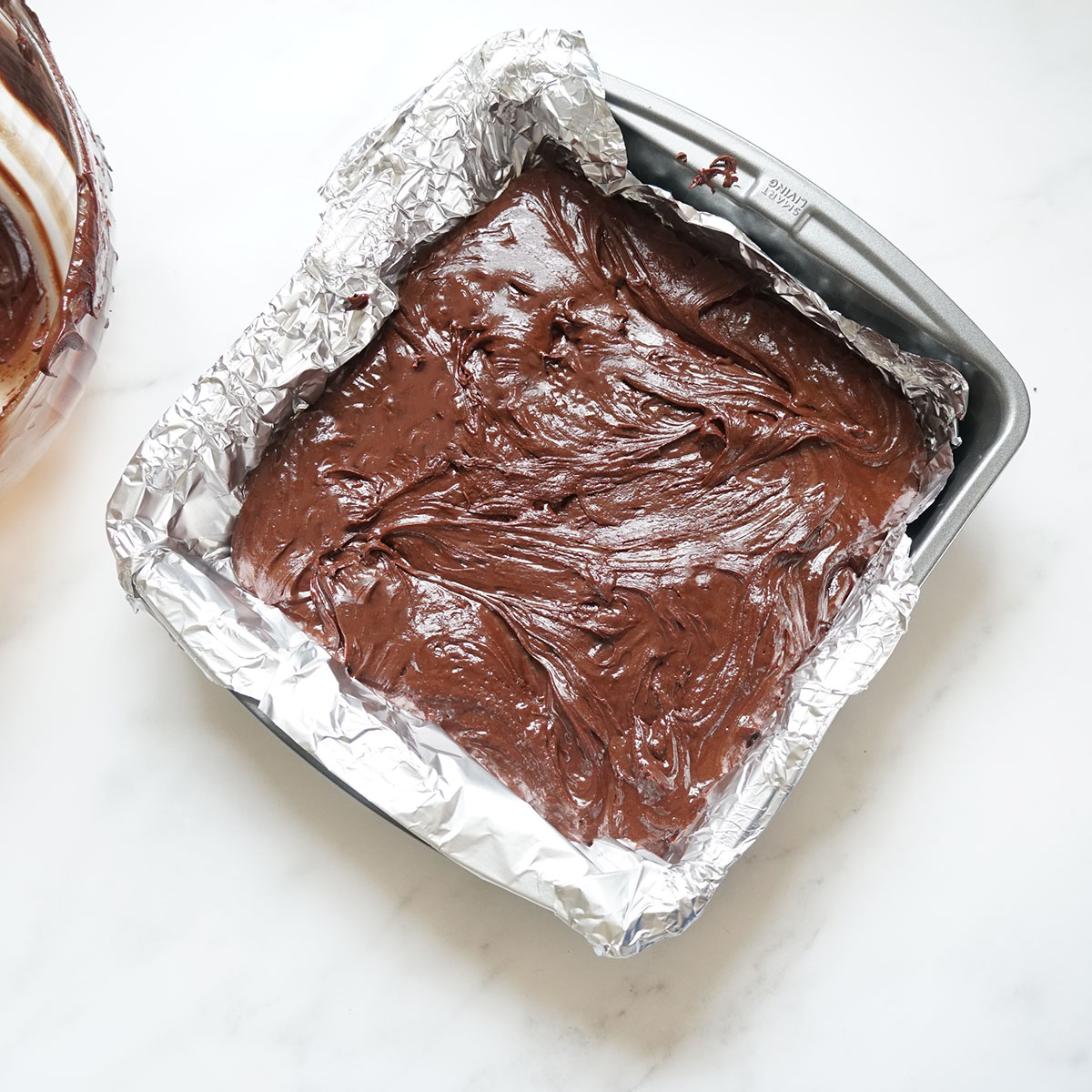 chocolate frosting fudge poured in baking pan 