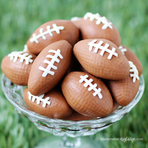 milk chocolate fudge footballs in a candy dish set on grass