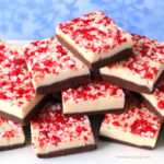 peppermint bark fudge with crushed candy canes on layers of dark and white chocolate fudge