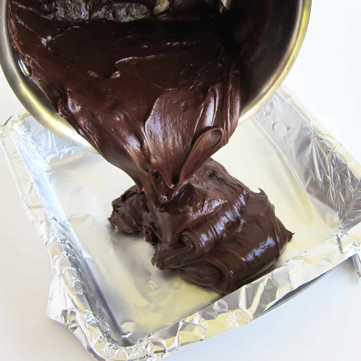 pouring Andes Mint fudge into a tin foil-lined baking pan