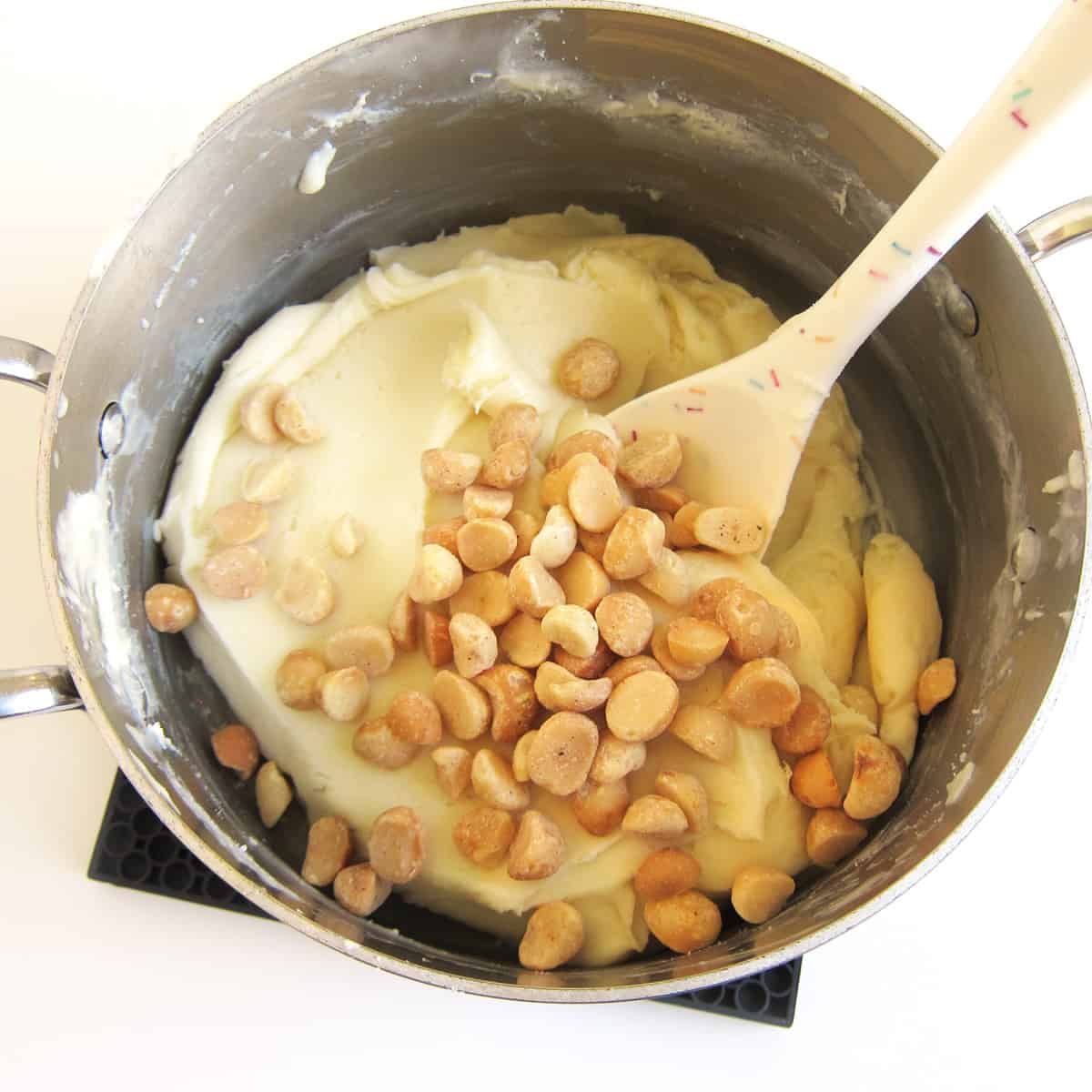 Stir macadamia nuts poured into white chocolate fudge.