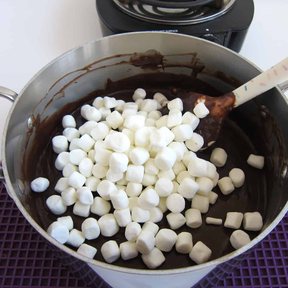 add mini marshmallows into the pan of hot cocoa fudge.