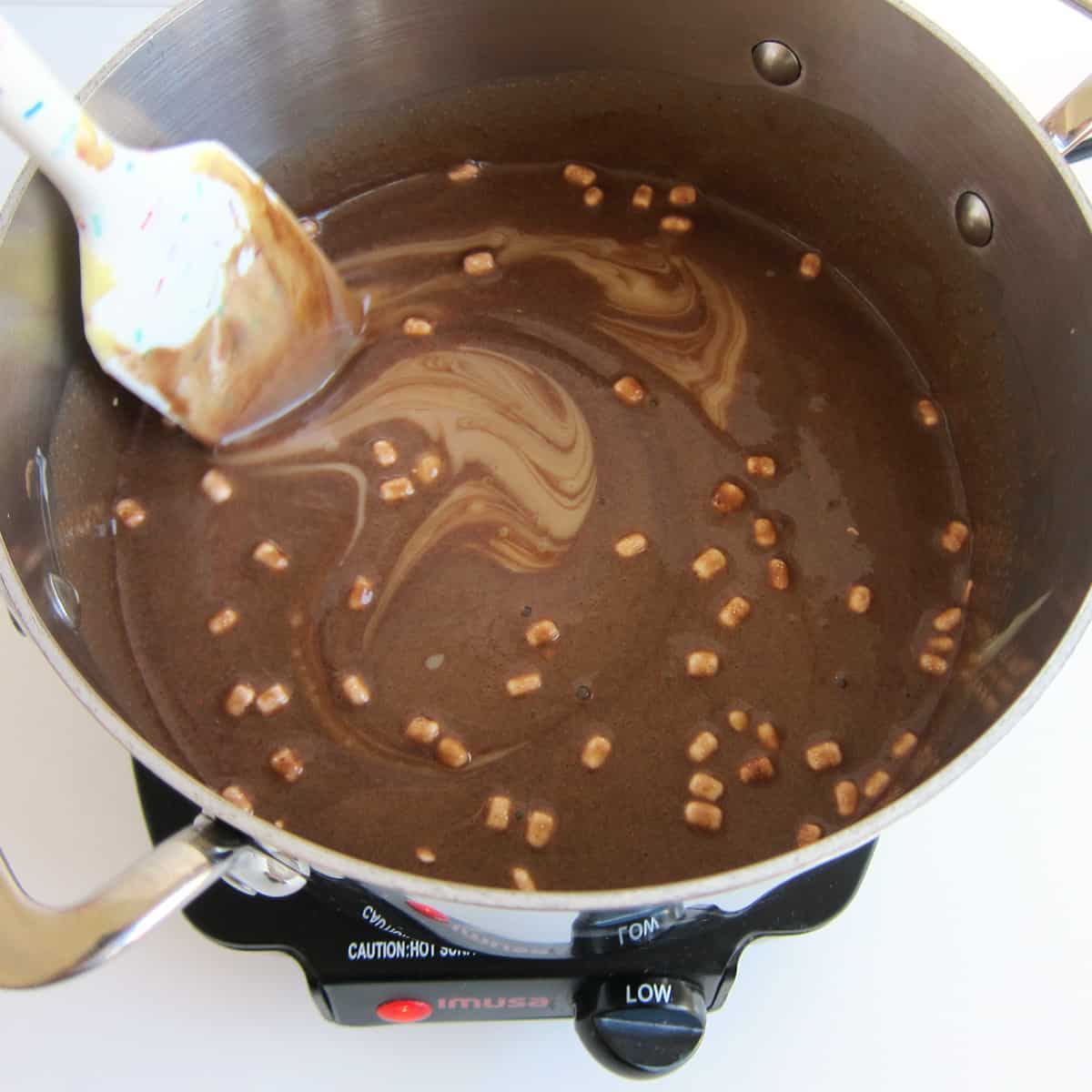 stirring sweetened condensed milk into the hot cocoa.
